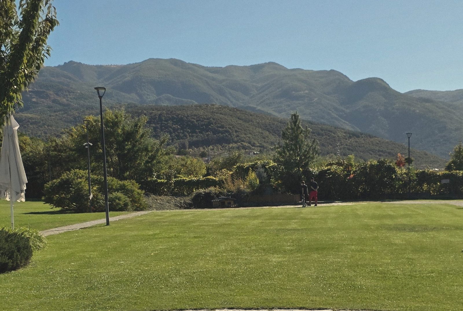 The lawns of Hills Brewery with the Rhodope mountains behind